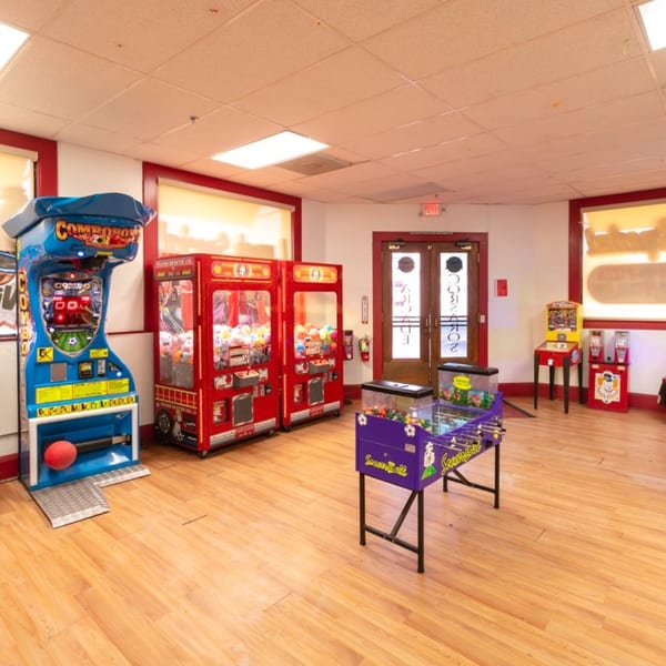 Arcade room at Corsaro's Family Pizza with various games, including claw machines and a foosball table.